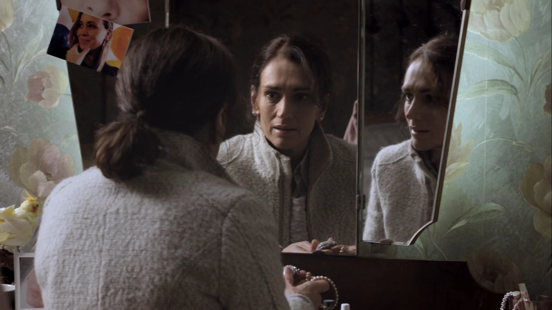 A woman and her reflections in a dressing table mirror, in Kill