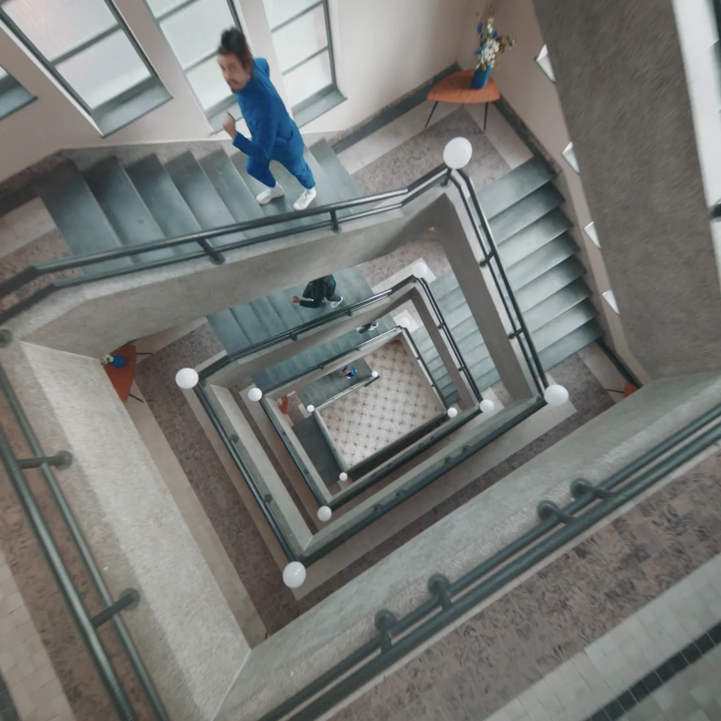 Looking down the stairwell at a woman running up the stairs
