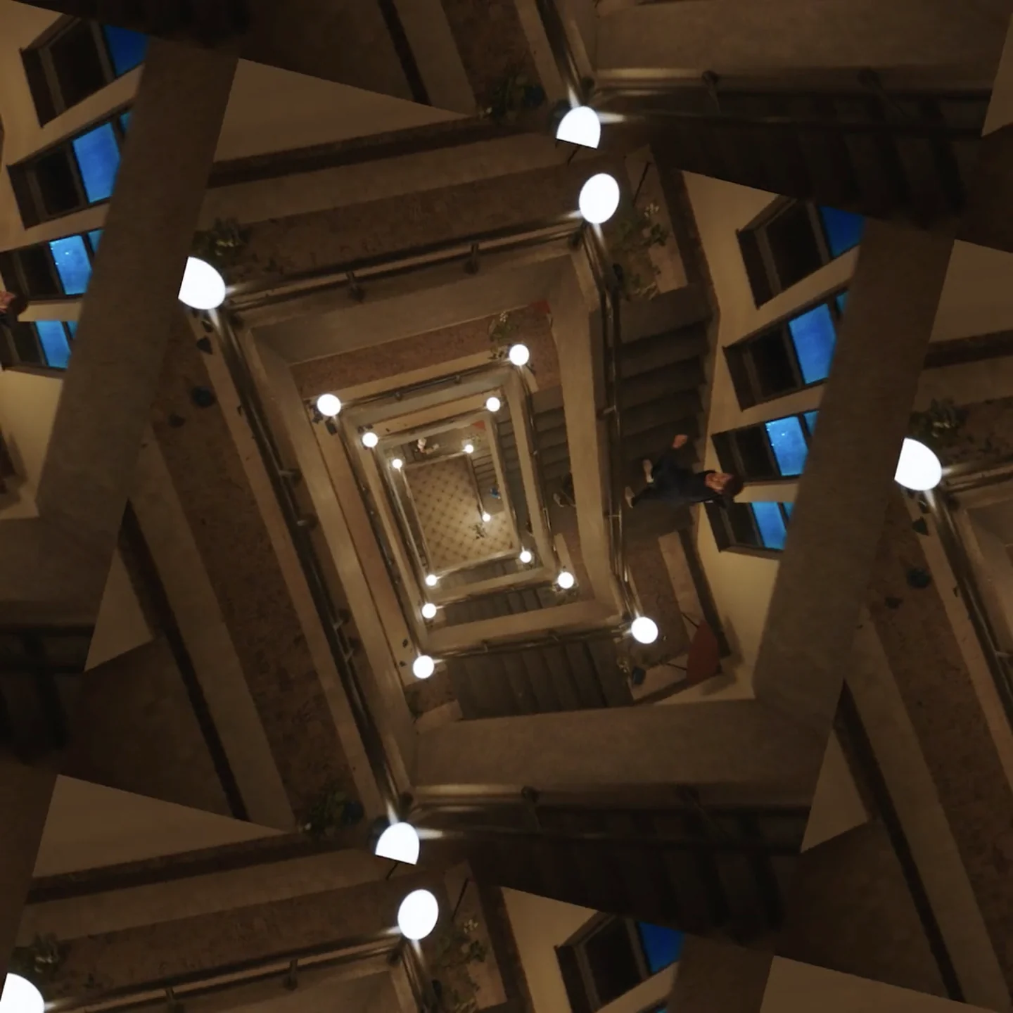 A mirrored view of the stairwell at night, steps folding in on themselves