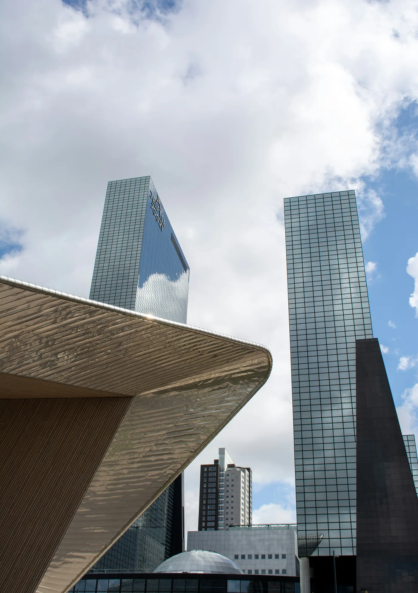 Glass towers and the steel roof of Rotterdam Centraal against the clouds
