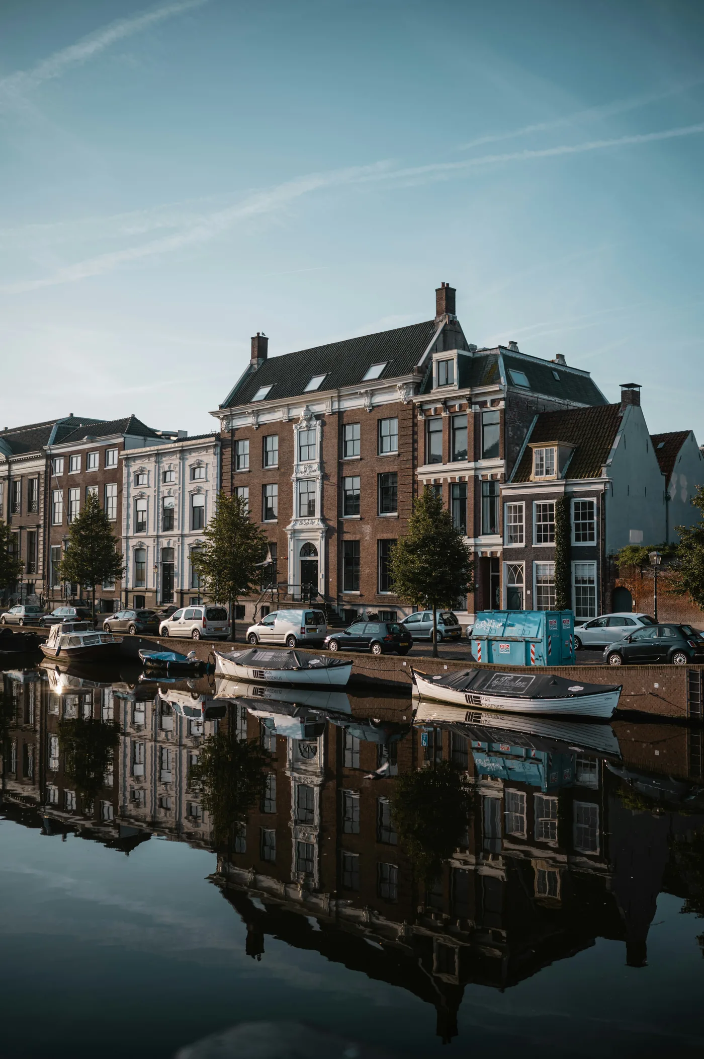Grand canal houses and moored boats reflected in still water