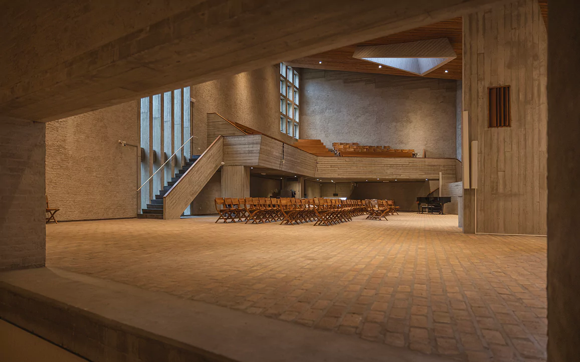 A large concrete interior with tall windows