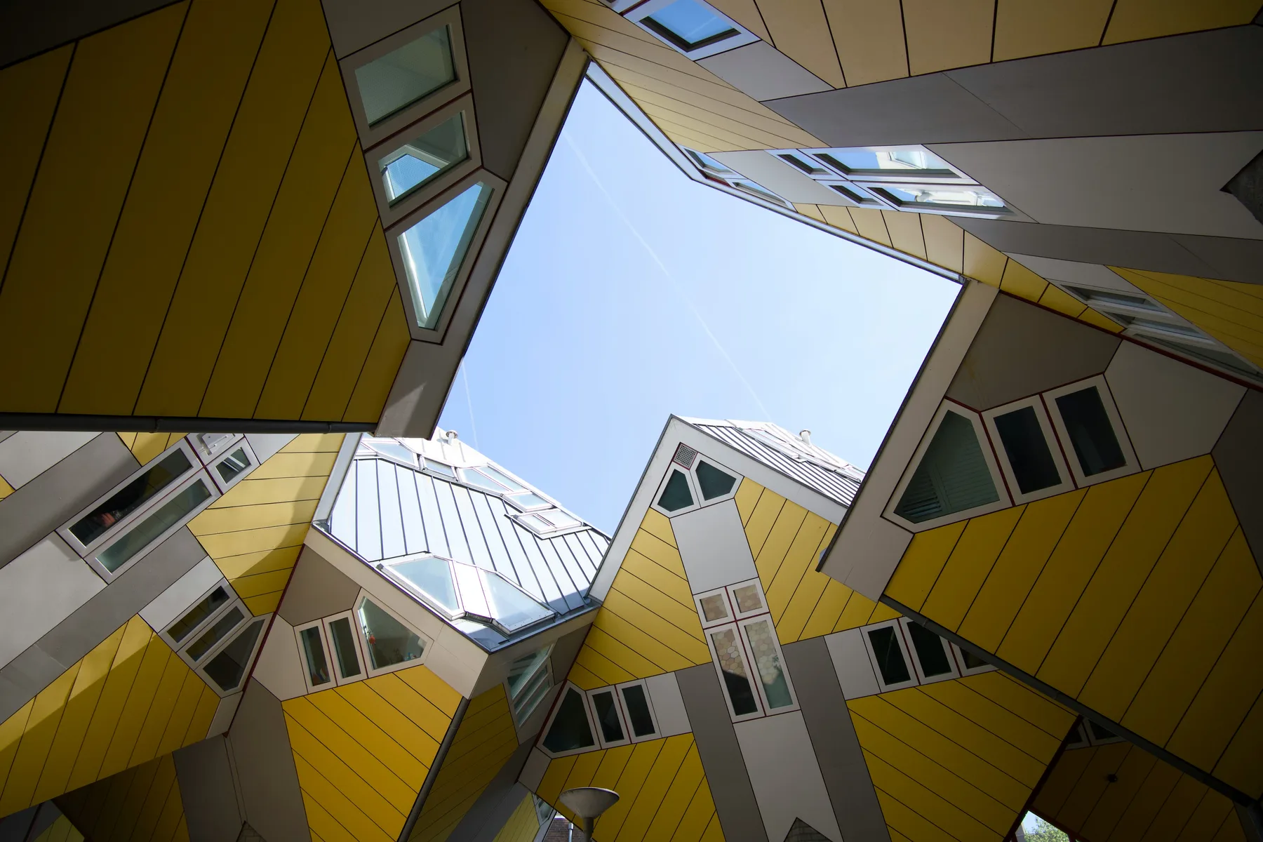 Looking up between the yellow Cube Houses at the sky
