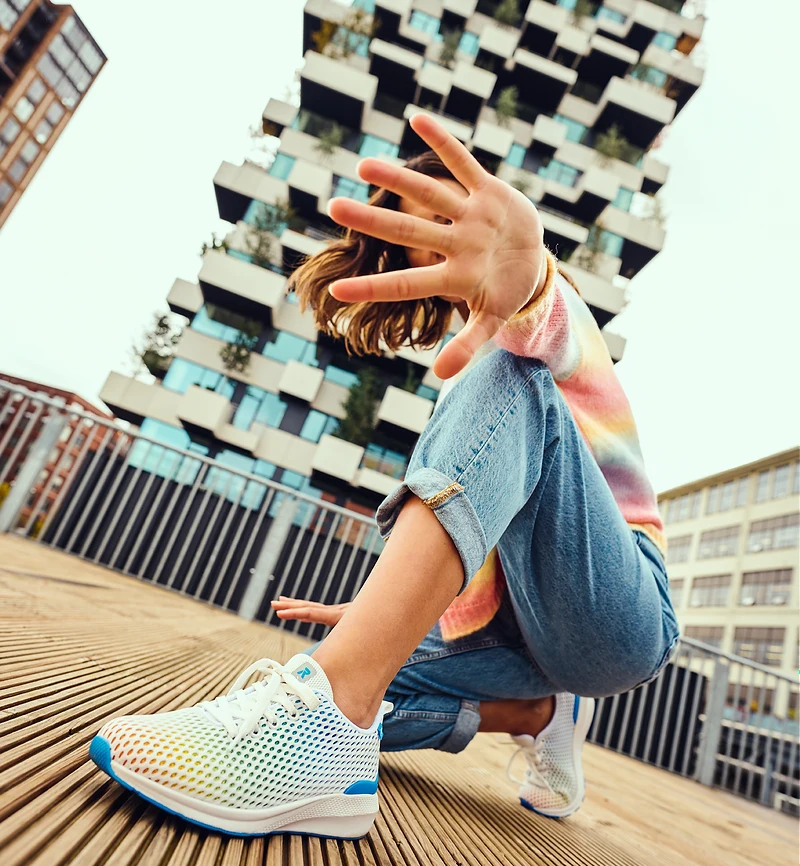 Model in Rieker sneakers crouching in front of the Trudo tower at Strijp-S, Eindhoven