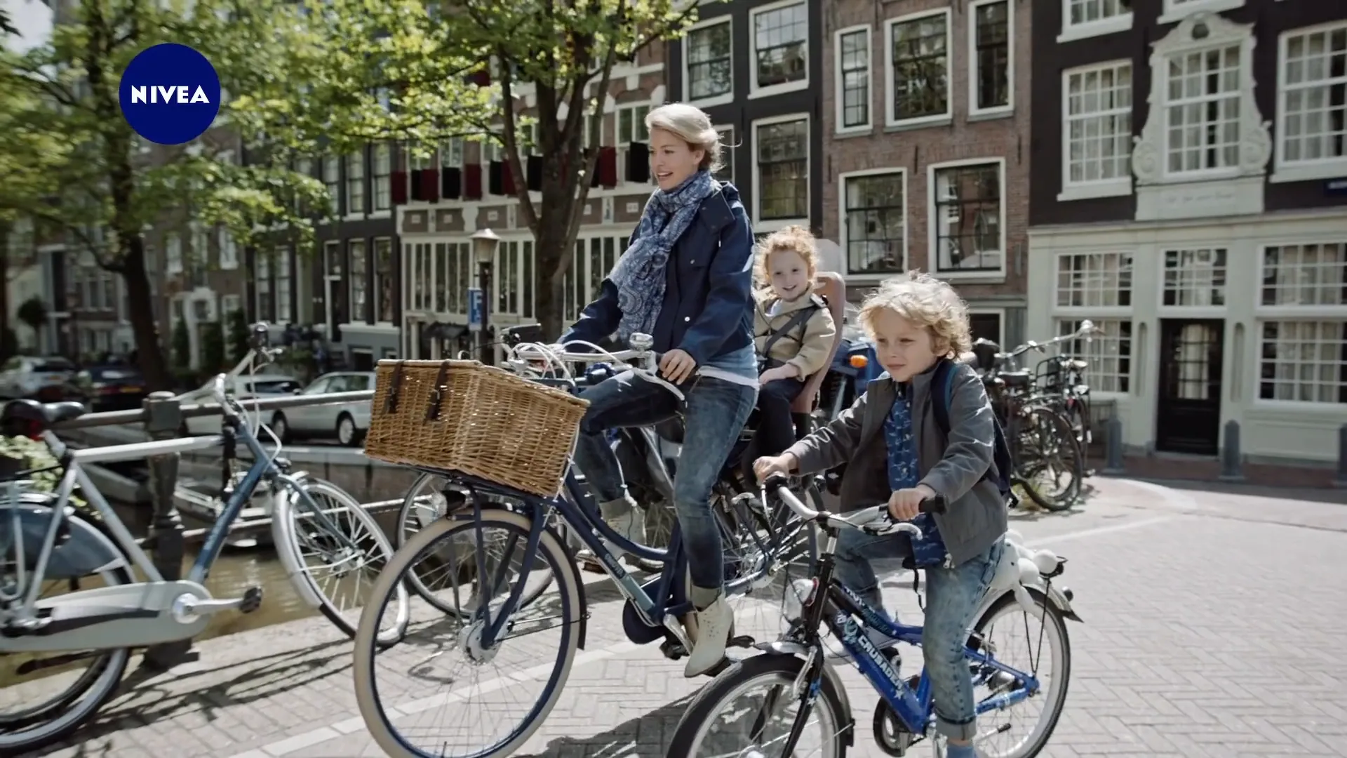 A mother and her children cycle past canal houses in Amsterdam, from the Nivea Crème commercial
