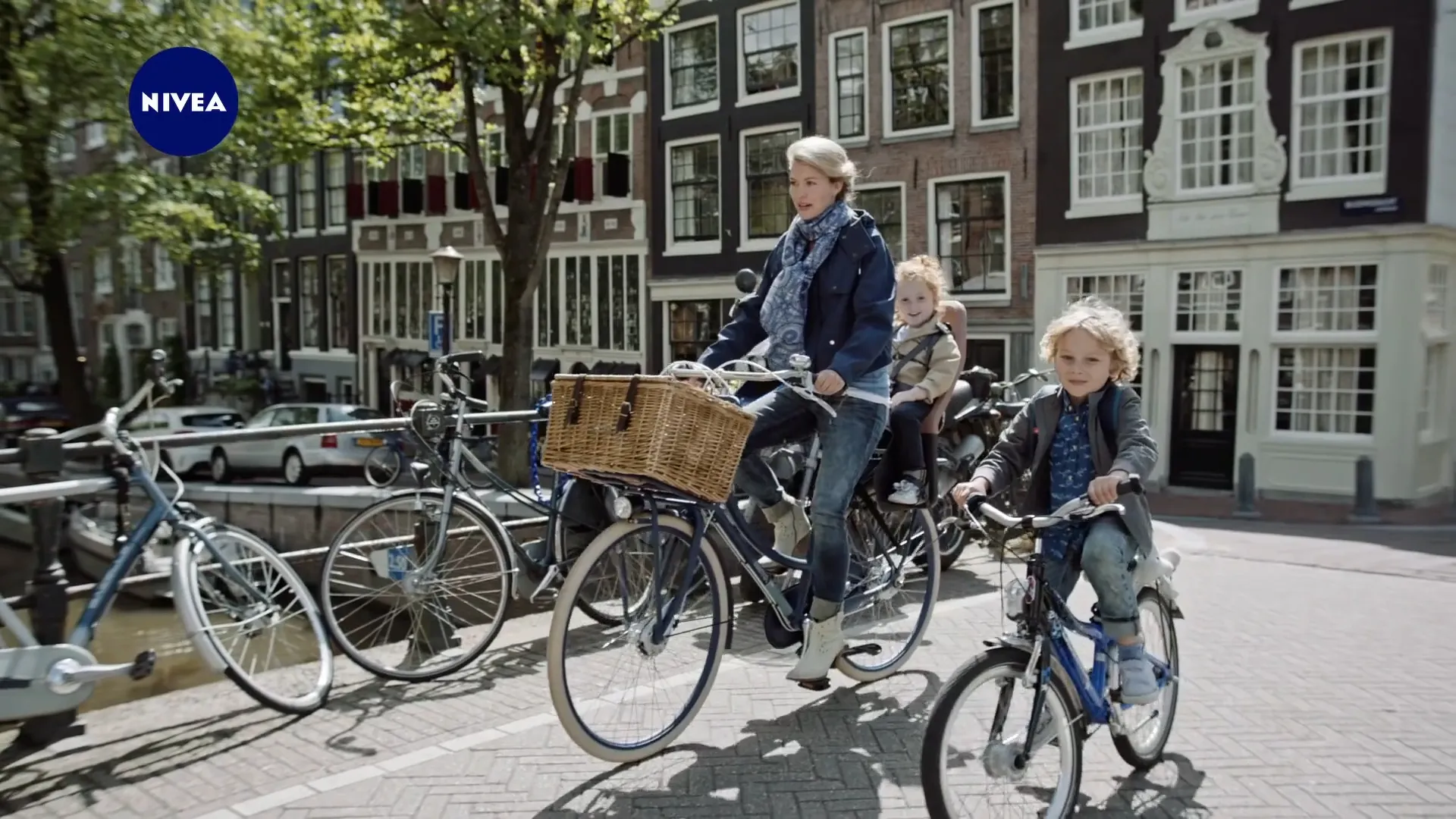 A mother and two children cycle along an Amsterdam canal, from the Nivea Cr&egrave;me commercial