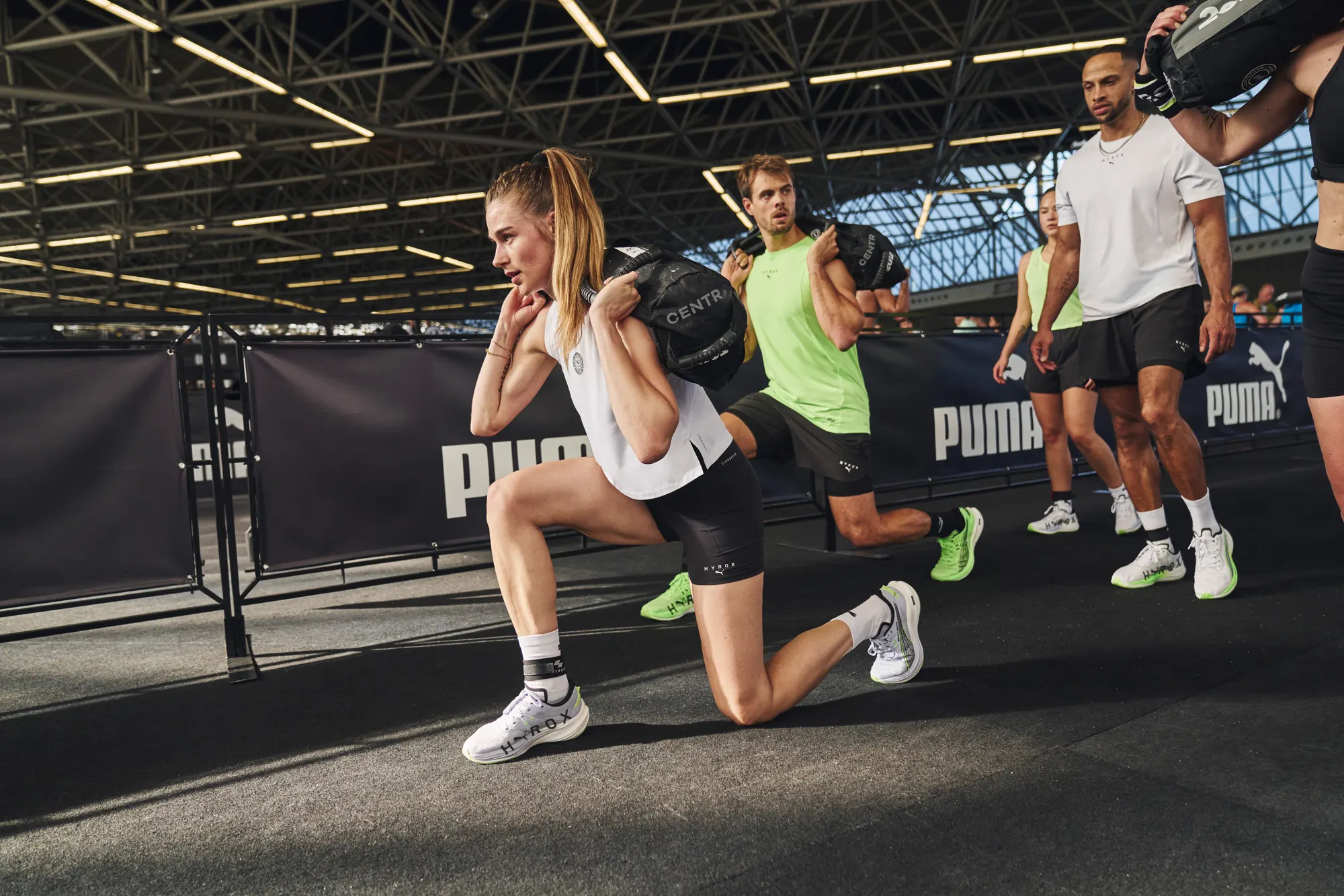 Athletes lunging with sandbags