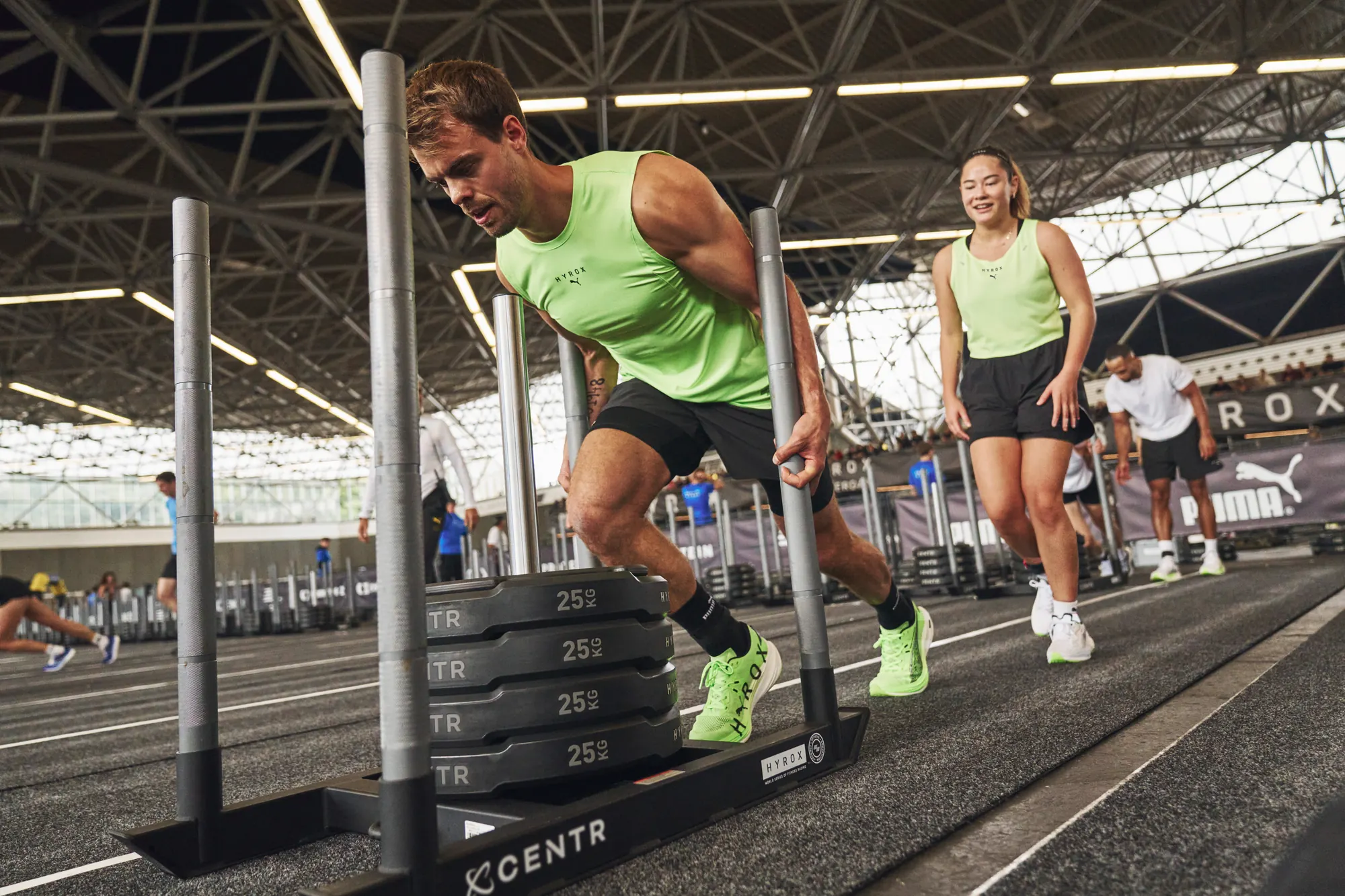 Two athletes pushing weighted sleds