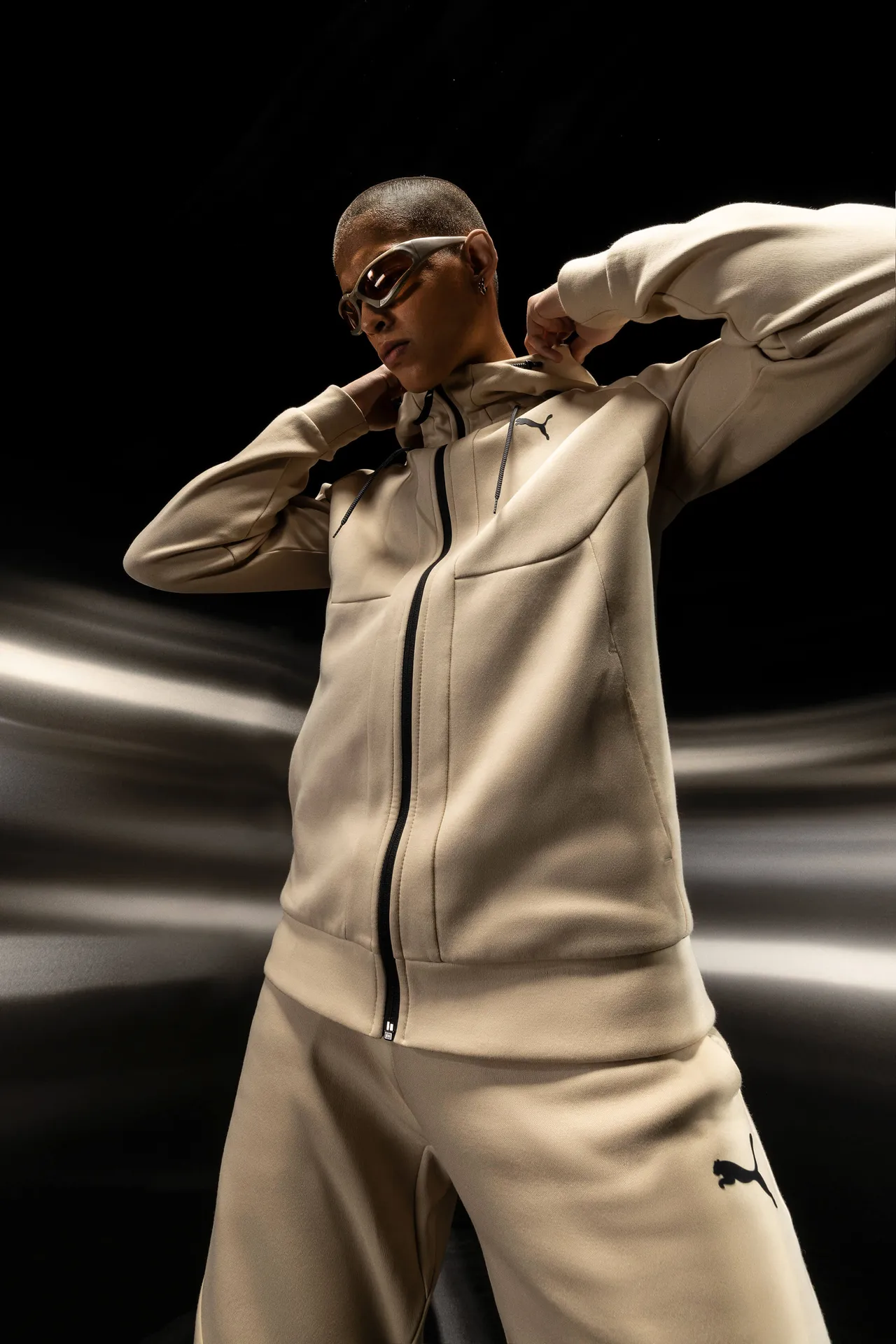 Model in a beige PUMA Tech tracksuit against light trails