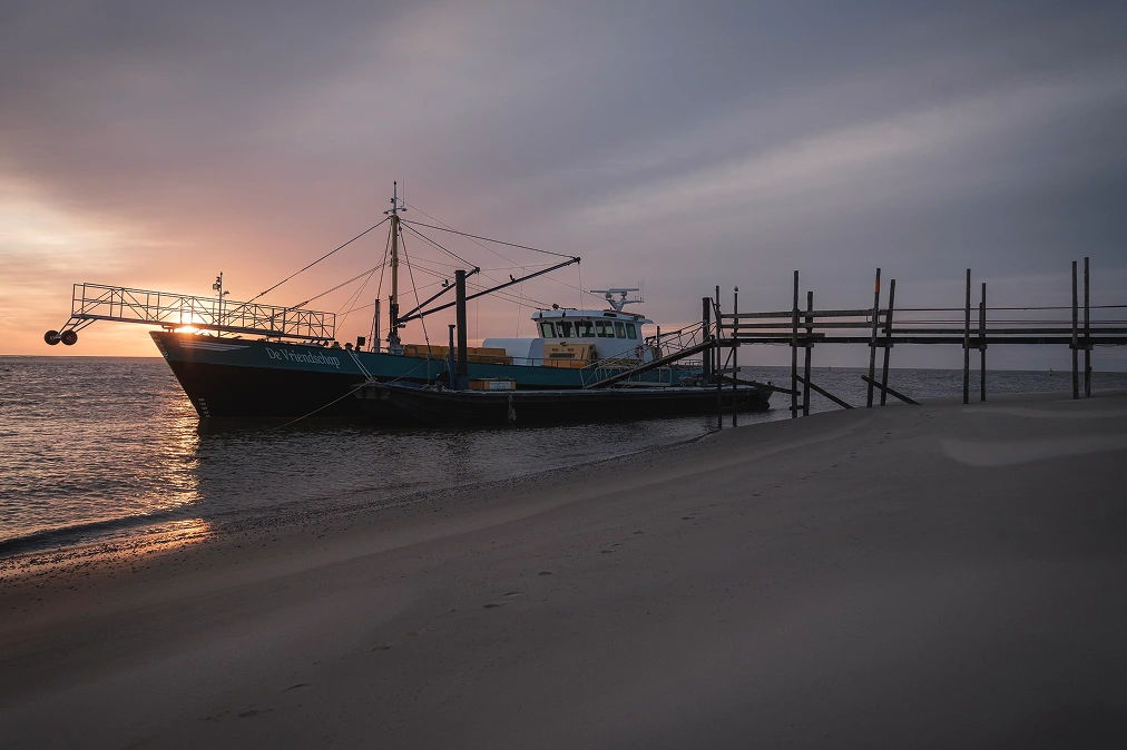 A ship moored in a harbour at dusk