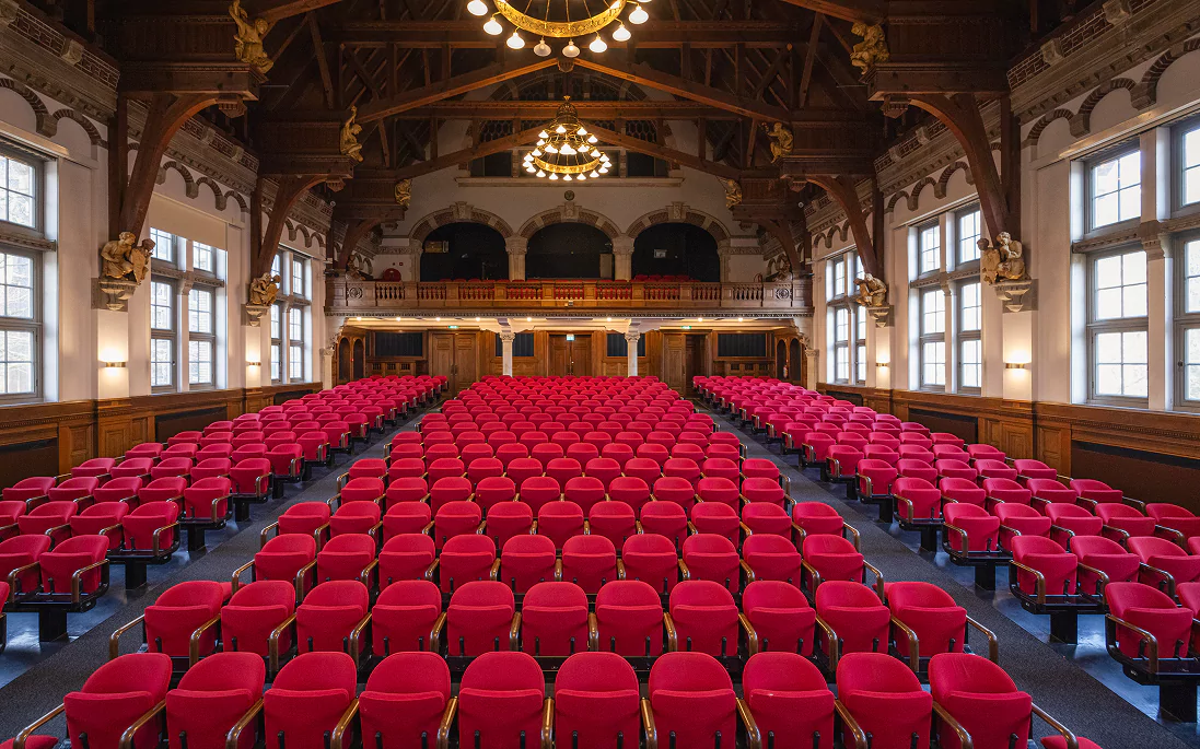 A theatre hall with rows of red seats
