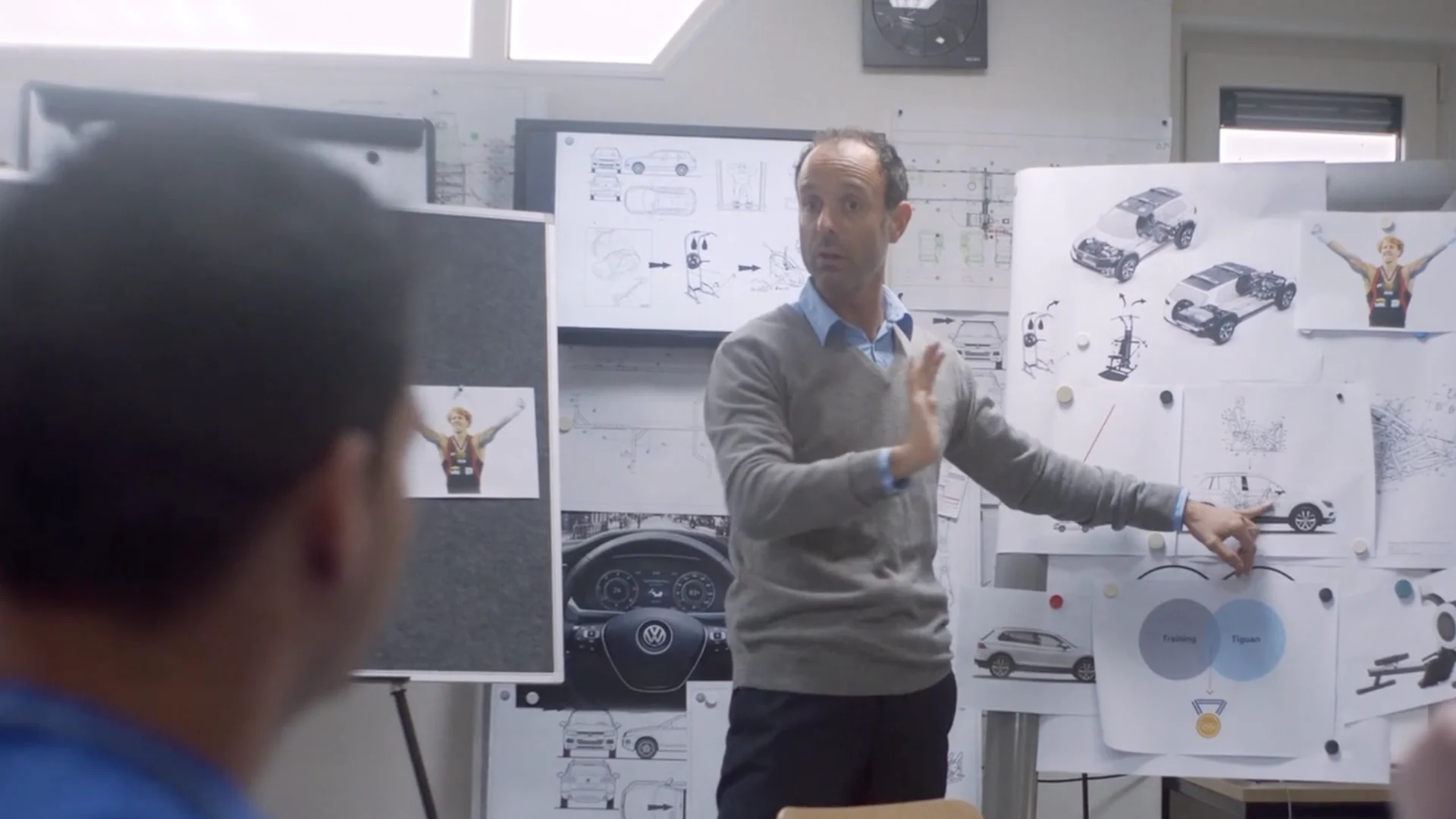 An engineer explains the plan at a wall of sketches of Epke and the Tiguan